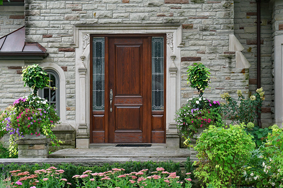 stone faced house with flower garden and elegant wooden front do