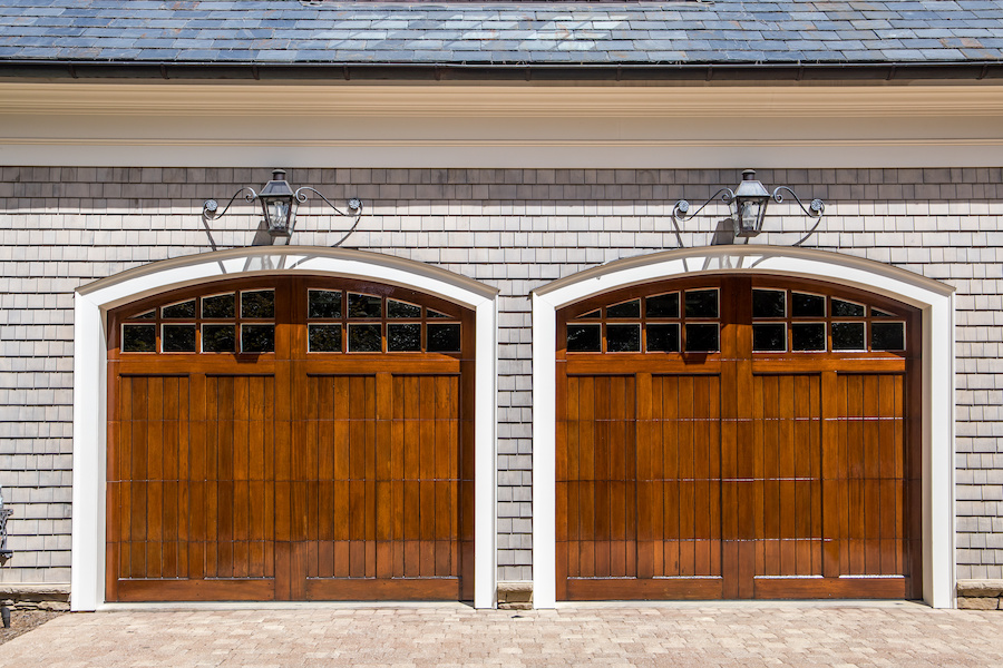 Stained wood custom garage doors for large southern home with curb appeal